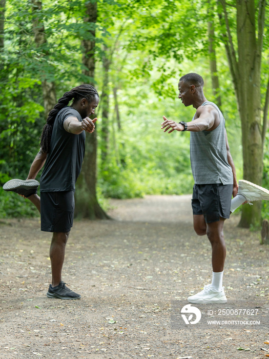 Two men stretching in forest