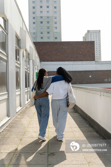 Young female couple walking in city