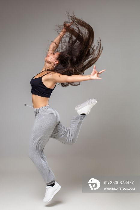 Modern style dancer posing on studio background. Hip hop, jazz funk, dancehall