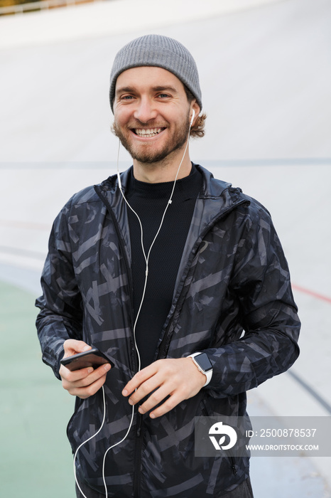Motivated young fit sportsman listening to music