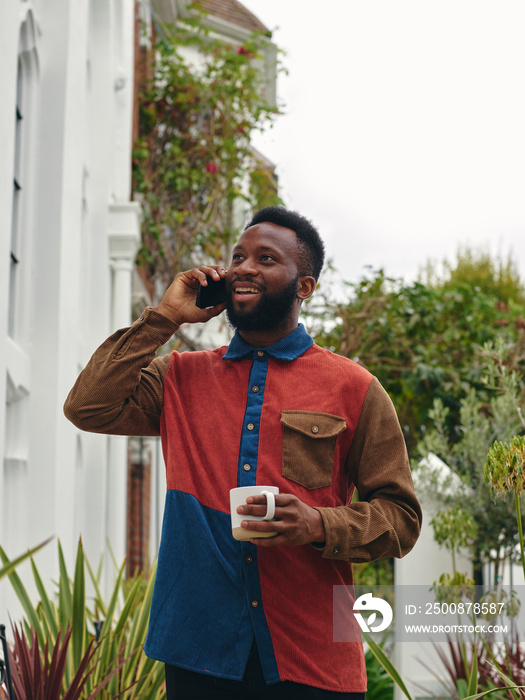 UK, London, Smiling man talking on smart phone outdoors