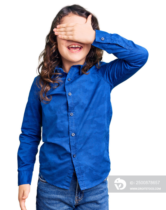 Cute child with long hair wearing casual clothes smiling and laughing with hand on face covering eyes for surprise. blind concept.