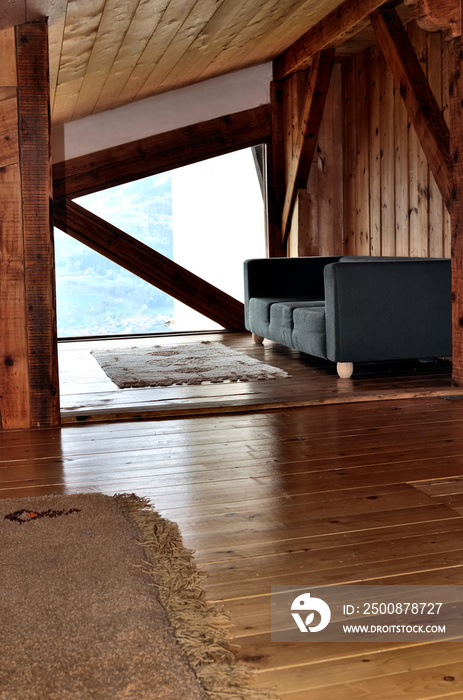 intérieur bois d’un chalet sous pente de toit avec canapé