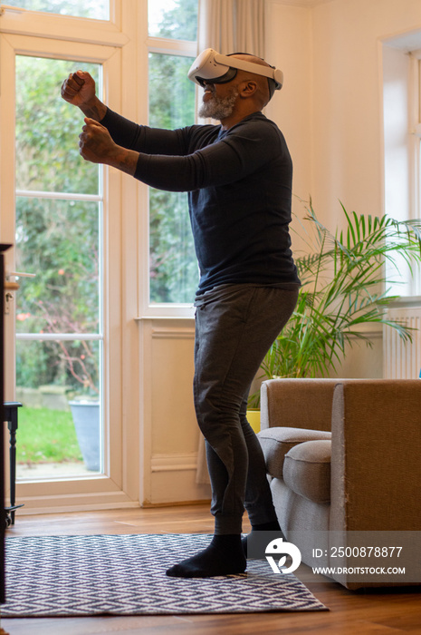 Mature man playing game using VR headset