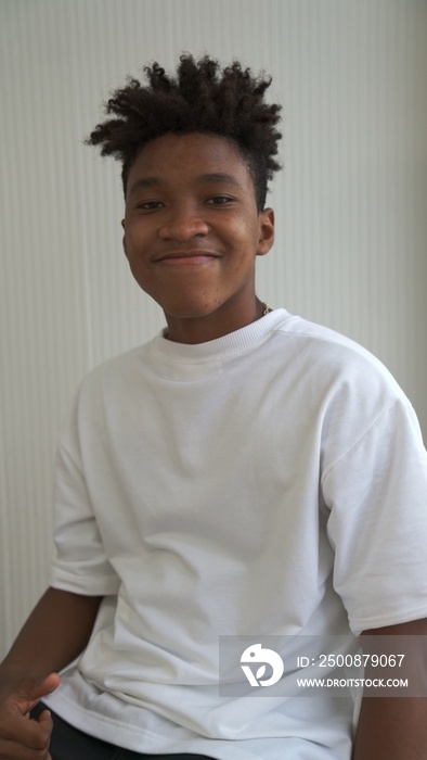 Portrait of young African American teenager merrily pose in studio on clear background .