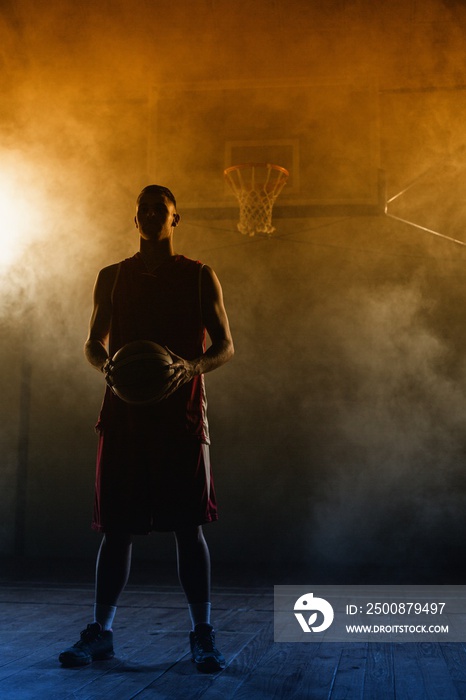 Portrait of a basketball player holding a ball in his hands