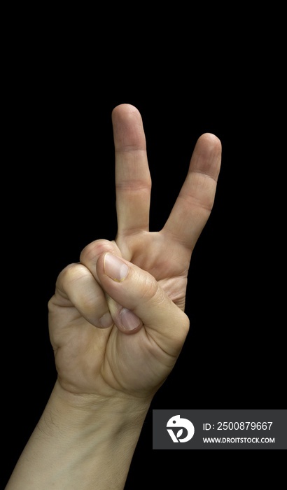 A male hand making the victory sign with his fingers, arranged in the letter V, black background