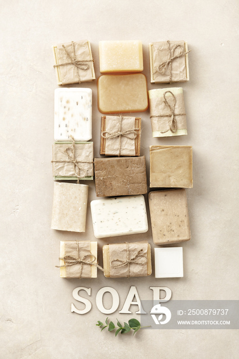 Flat lay composition with handmade soap bars and wood letters on beige background