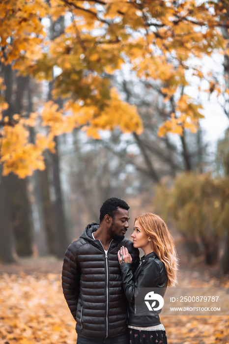 Interracial couple posing in blurry autumn park background