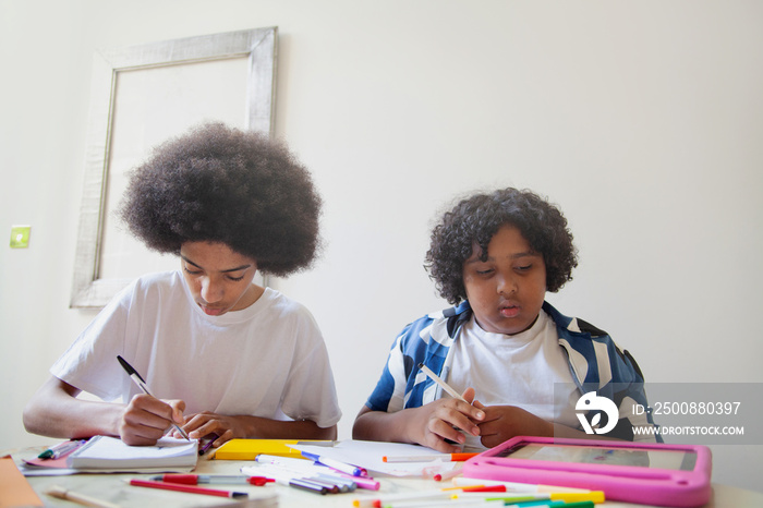 Two mixed-race brothers helping each other with homework