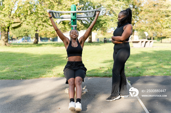 Young female friends working out in outdoor gym