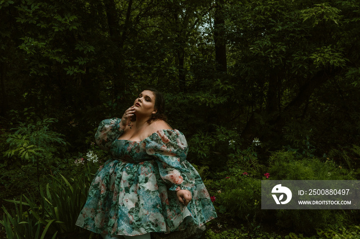 portrait of a plus size woman in a floral dress in a forest