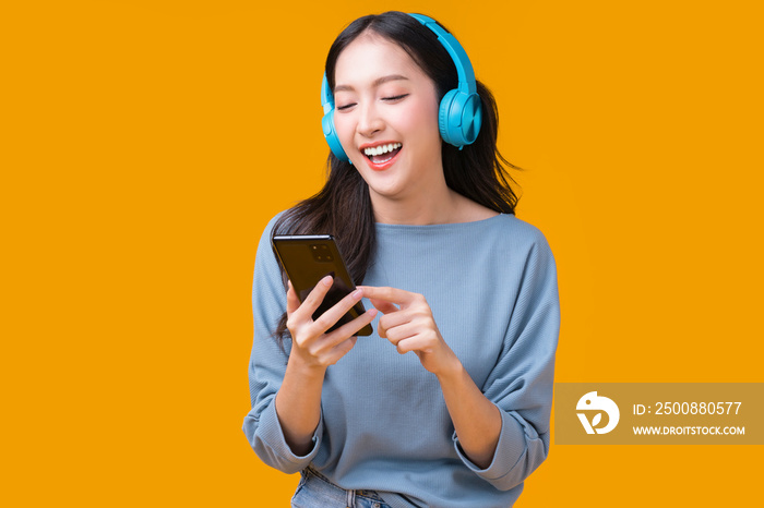 happiness carefree asian young female woman teen wearing headphone smartphone listen music joyful fun moving moment ,teen wear casaul cloth singing move while laugh smile trendy lifestyle studio shot