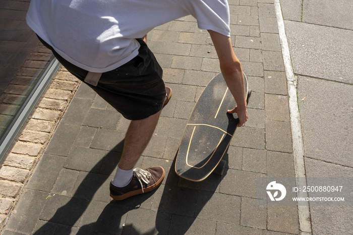 Young man skateboarding on sidewalk