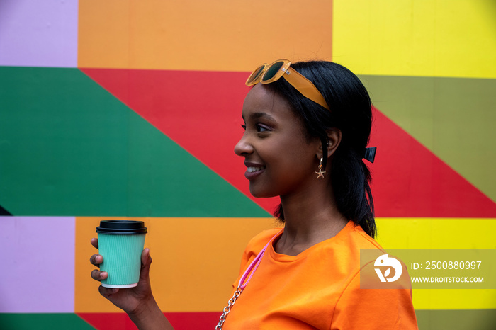 Young woman drinking take-out coffee outdoors