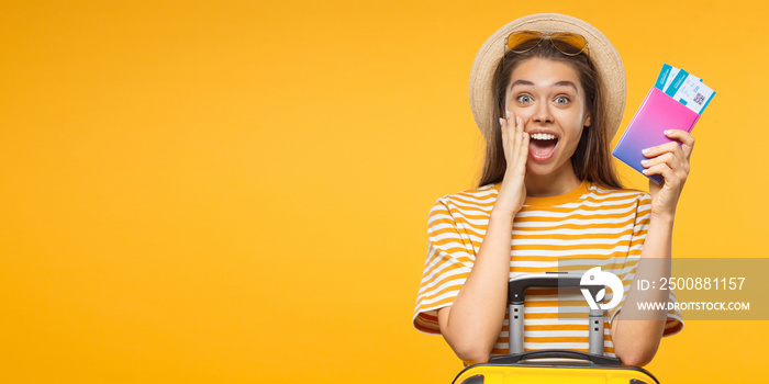 Horizontal banner of excited screaming WOW young woman tourist with suitcase and passport, isolated on yellow background with copy space