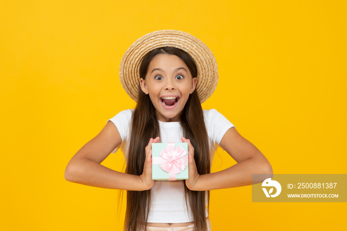 surprised teen kid hold present box on yellow background