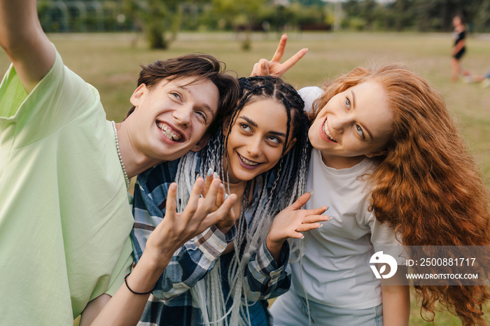 Happy friends having fun taking group selfie portrait on city park. Taking selfies together. Memories and vivid impressions, group of young friends. Summer