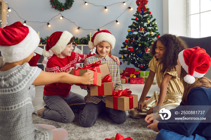 Happy little girl getting lots of Christmas presents from her kind friends or siblings