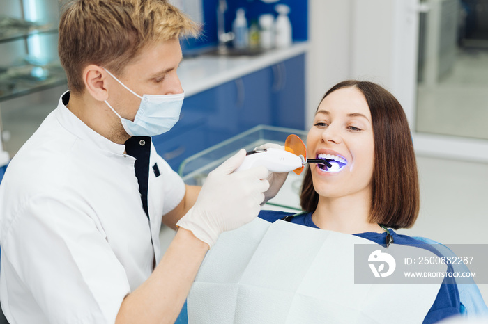 Close-up portrait of a female patient visiting dentist for teeth whitening in clinic