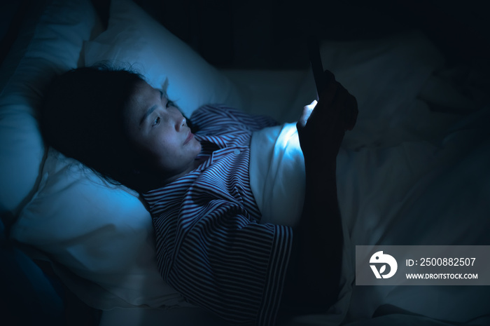 Asian woman playing game on smartphone in the bed at night,Thailand people,Addict social media