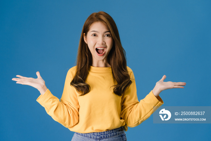 Young Asia lady feeling happiness with positive expression, joyful surprise funky, dressed in casual cloth and looking at camera isolated on blue background. Happy adorable glad woman rejoices success