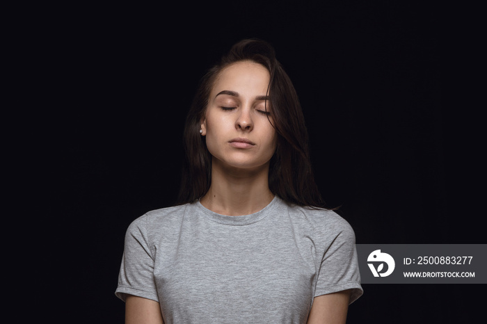 Close up portrait of young woman isolated on black studio background. Photoshot of real emotions of female model with closed eyes. Thoughtful. Facial expression, human nature and emotions concept.