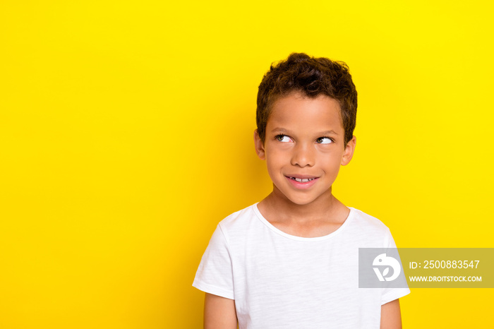 Photo of cute nice kid boy wearing white stylish clothes outfit look empty space imagines sweets isolated on yellow color background