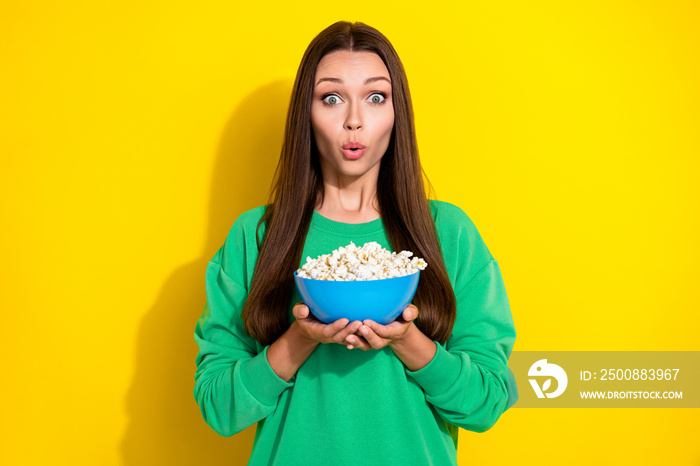 Photo of impressed girl pouted lips arms hold popcorn plate watch movie isolated on yellow color background