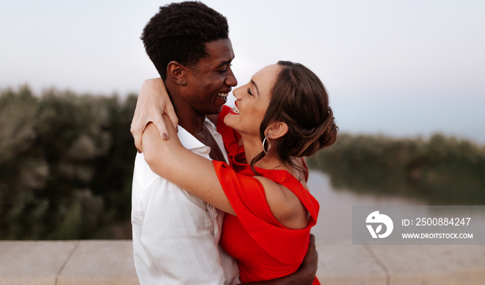 Cheerful couple embracing each other on a bridge