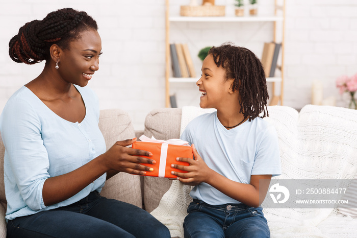 Little afro girl giving present for mothers day