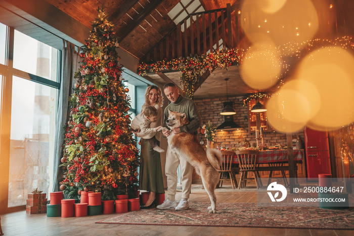 Candid authentic happy family during wintertime together enjoying holidays with dog at Xmas