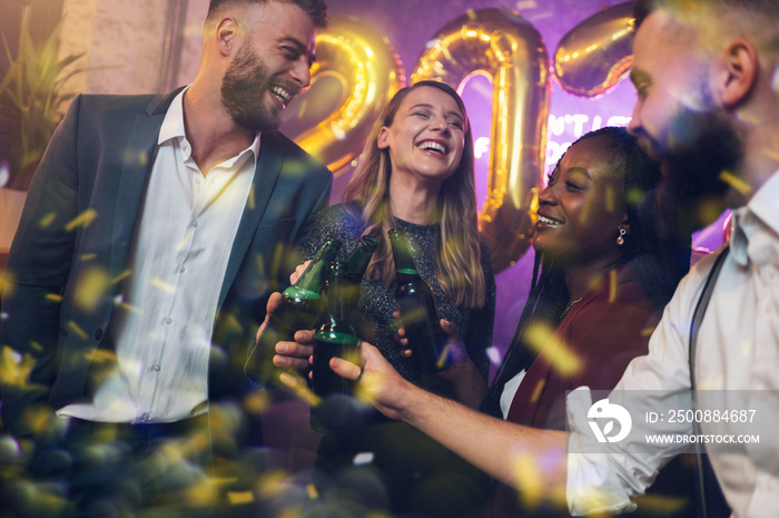 Happy group of friends celebrate New Year’s Eve while dancing in the club