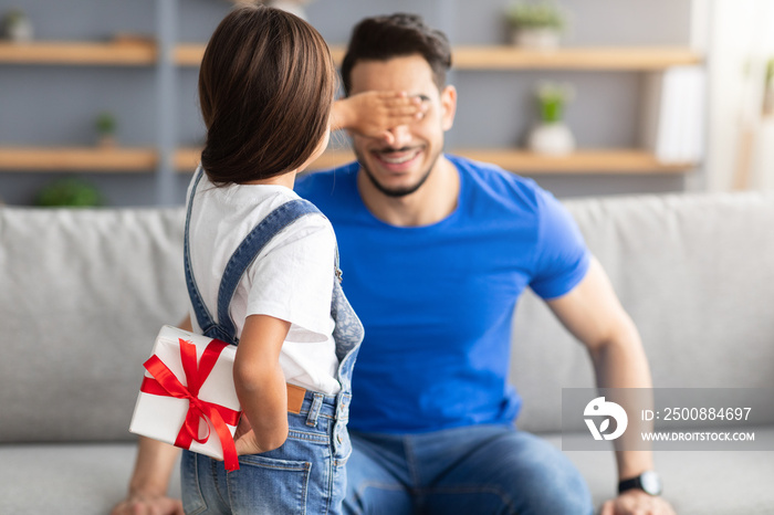 Little daughter celebrating father’s day, greeting excited dad with box