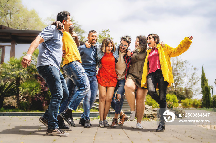 Group of multiethnic cheerful happy friends hugging and having fun walking together