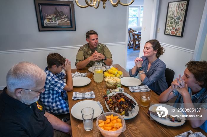 Air Force service member fixes and eats dinner with family.