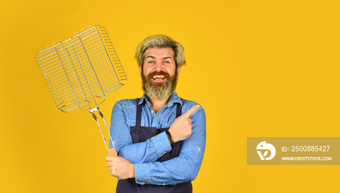 Culinary concept. Tools for roasting meat. Cooking utensils. Chef cooking bbq food. Summer picnic. Hipster dyed beard promoting bbq equipment. Cooking healthy. Man in apron hold barbecue grill