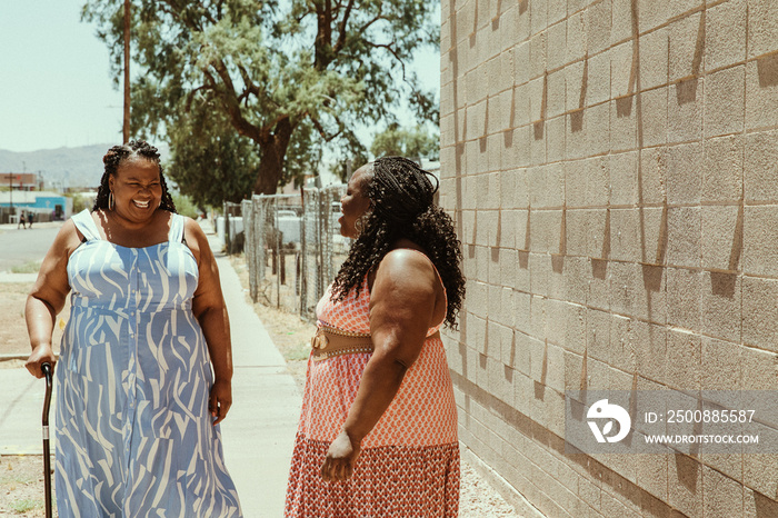 2 plus size African American women talk on the street