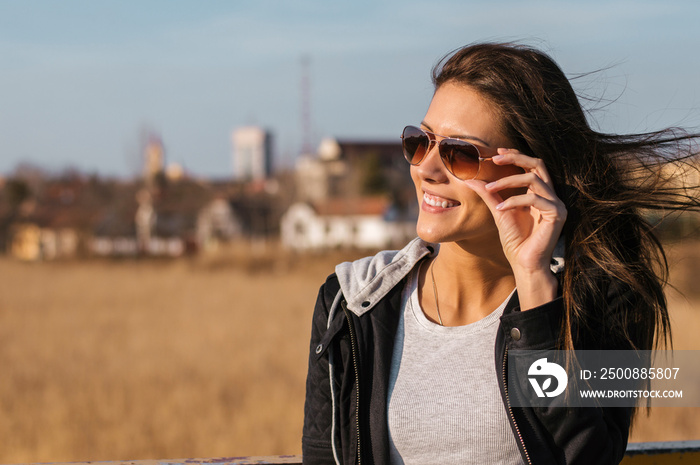 Portrait of a smiling woman wearing sunglasses outdoors