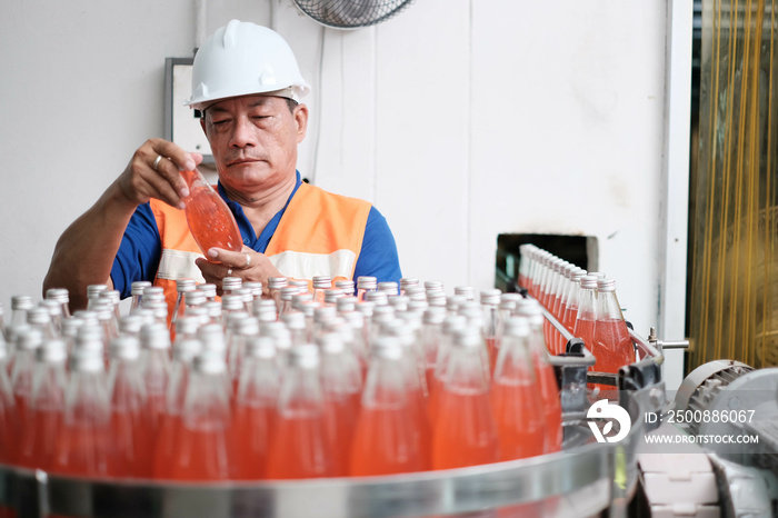 man worker using Checking quality or checking stock of products in beverage factory. Worker QC working in a drink water factory