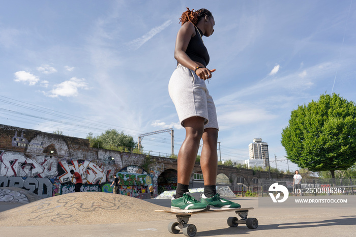 Young woman skateboarding in skate park