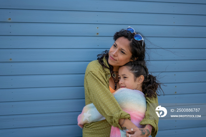 Mother and daughter (8-9) hugging outdoors