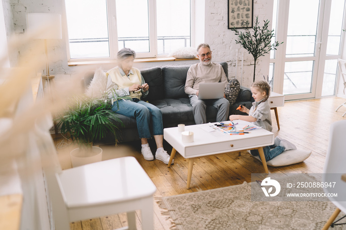 Grandfather and grandmother having family time with granddaughter