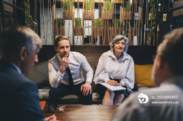 Coworkers having meeting in light office hall