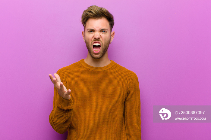 young man looking angry, annoyed and frustrated screaming wtf or what‚Äôs wrong with you against purple background