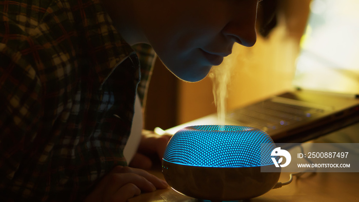 Woman inhale aromatic vapor from essential oil diffuser