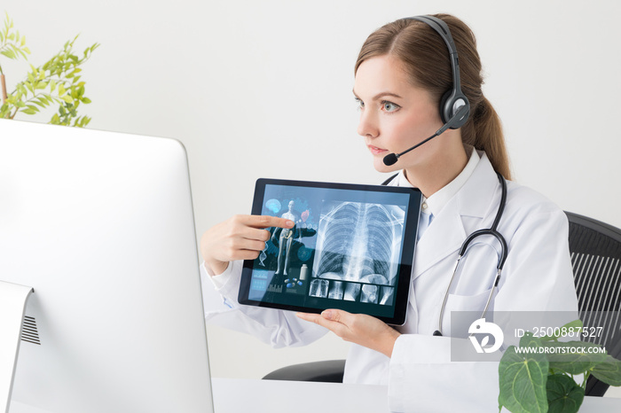 Remote medicine concept. Young woman doctor talking with a TV phone.