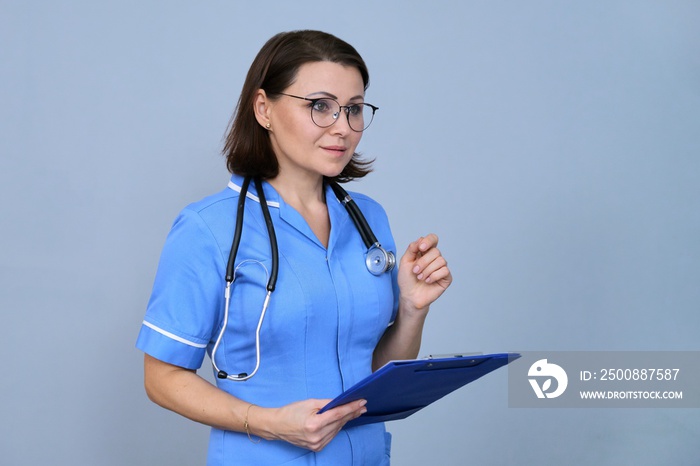 Portrait of mature nurse woman holding clipboard