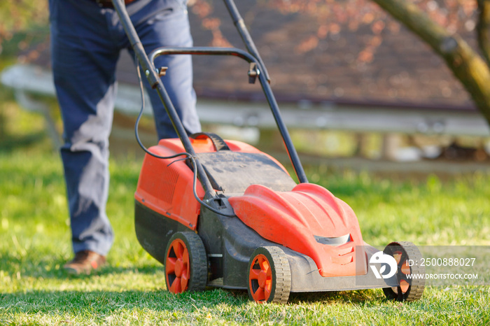 man mows the lawn grass with a lawn mower