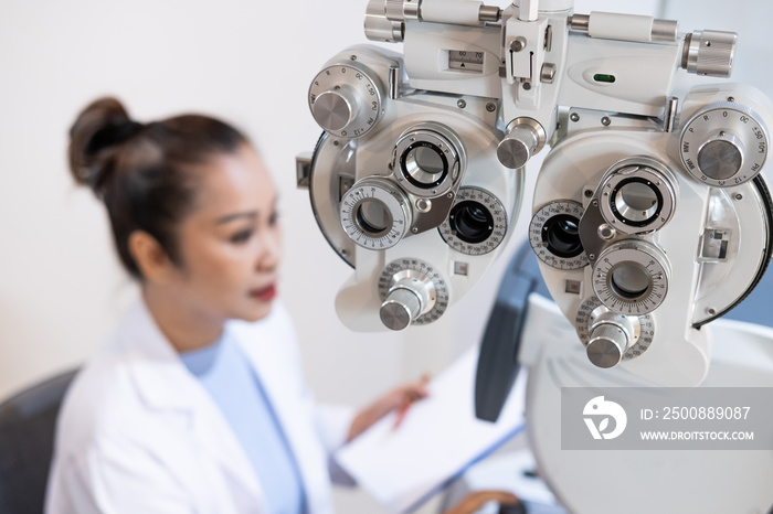 Selective focus at Optometry frame equipment. With blurred background while optometrist examine eye visual system of elder patient women with professional machine before made glasses.